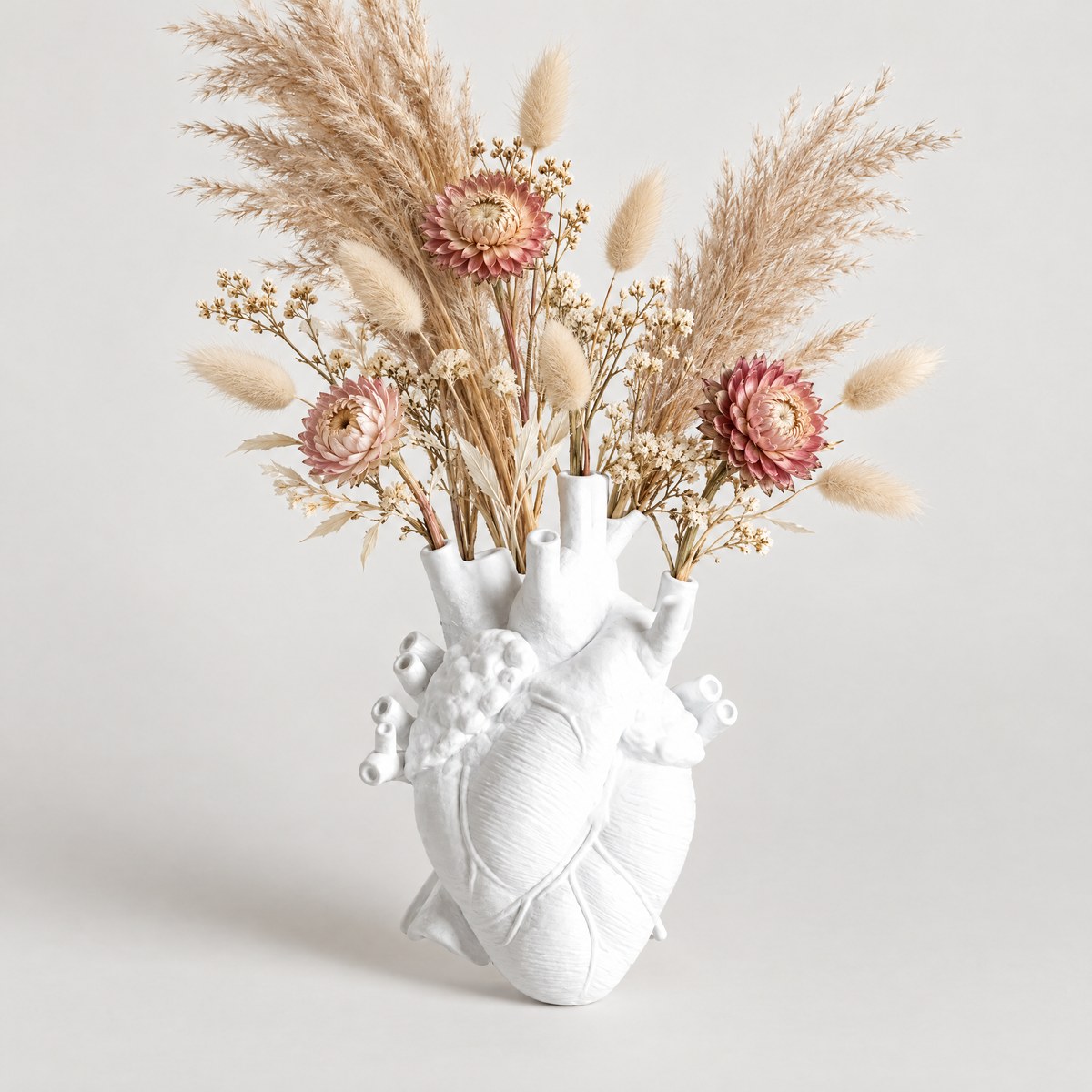 Cuore white anatomical heart vase holding dried flowers on white background