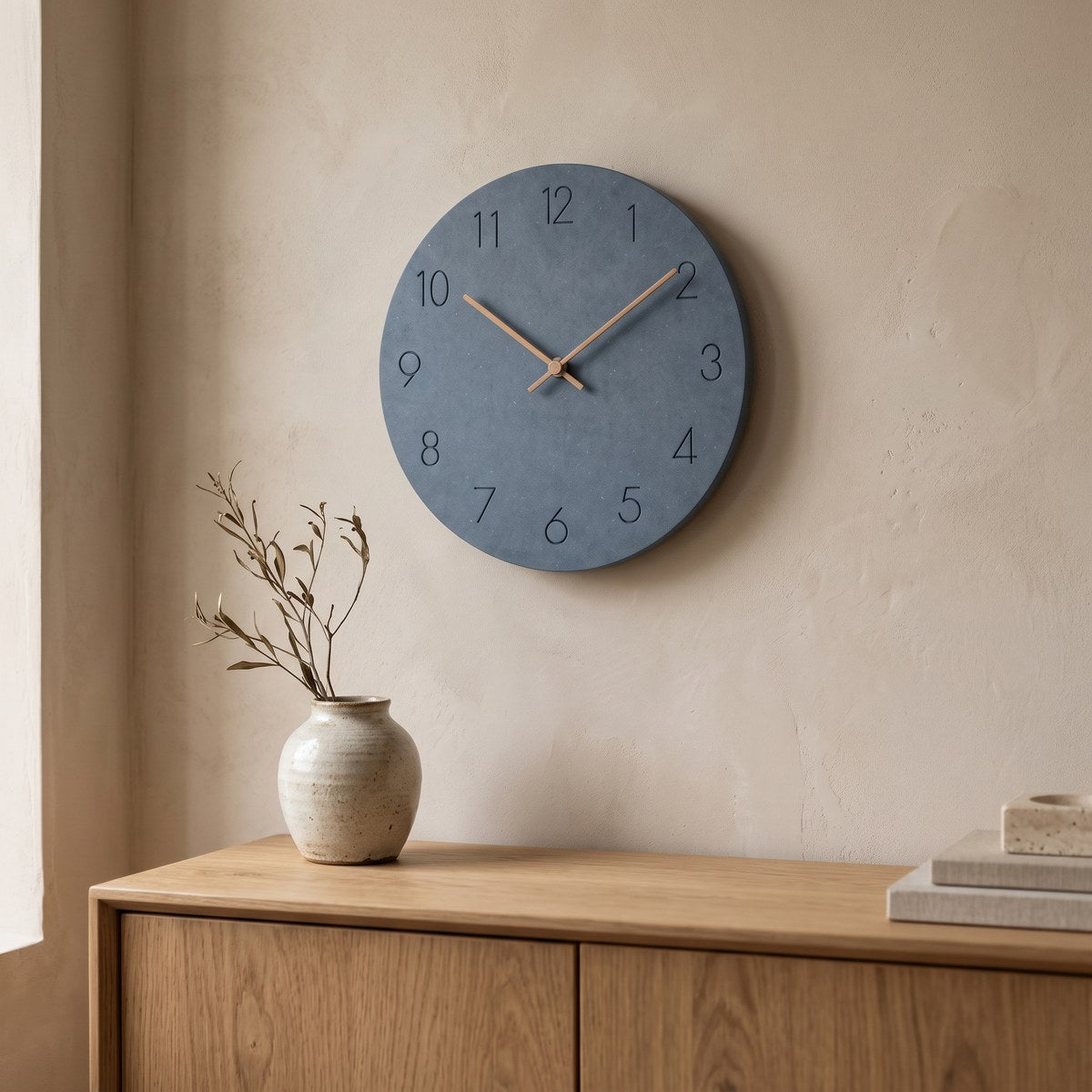 Hora minimalist wall clock hung above an oak sideboard in a calm living room