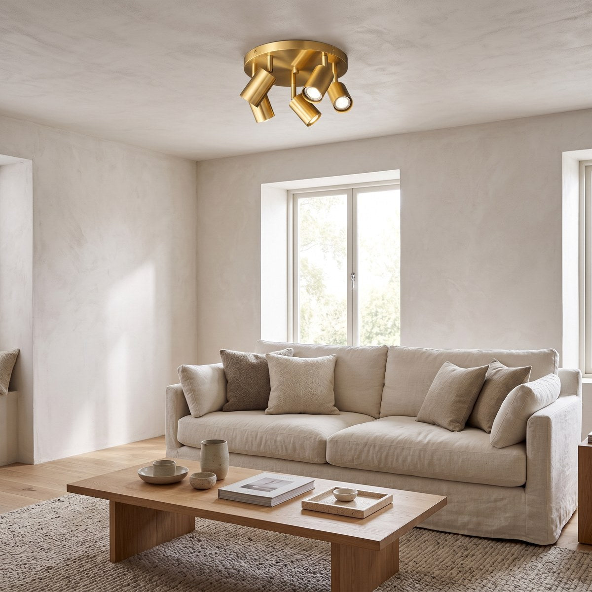 Kura brass five-spot ceiling light, 30cm (12in) across, above a linen sofa in a calm living room