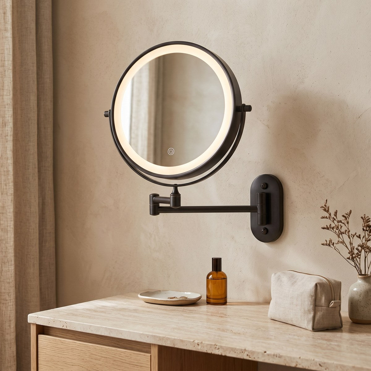 Ebon black LED makeup mirror glowing on a bathroom wall above a travertine basin