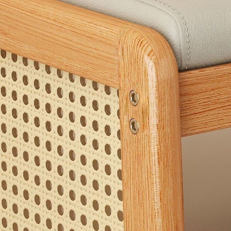 Close-up of the Varello bench's woven rattan panel and rounded oak frame